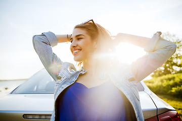 Image showing happy teenage girl or young woman near car