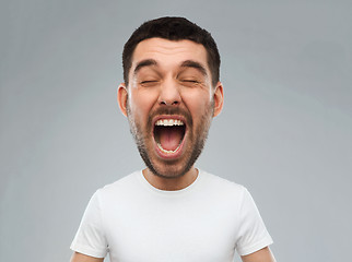 Image showing crazy shouting man in t-shirt over gray background