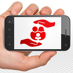 Image showing Insurance concept: Hand Holding Smartphone with Family And Palm on display
