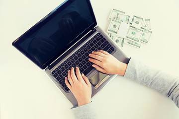 Image showing close up of woman hands with laptop and money