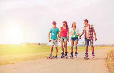 Image showing group of smiling teenagers with roller-skates