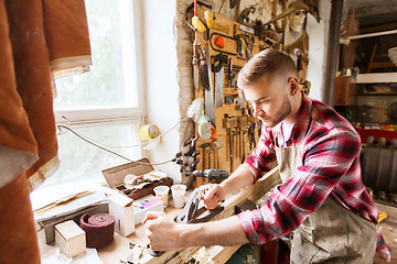 Image showing carpenter working with plane and wood at workshop