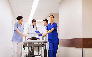 Image showing medics with woman on hospital gurney at emergency