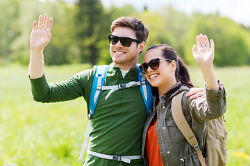 Image showing happy couple with backpacks hiking outdoors