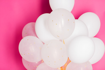 Image showing close up of white helium balloons over pink