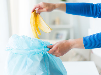 Image showing close up of hand putting food waste to rubbish bag