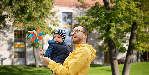 Image showing happy father and son with pinwheel toy outdoors