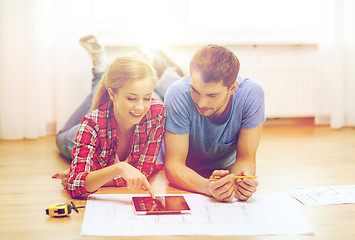 Image showing smiling couple looking at tablet pc at home