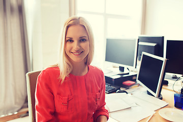 Image showing happy creative female office worker with computers