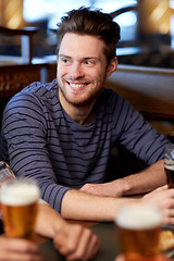 Image showing happy male friends drinking beer at bar or pub