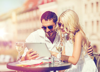 Image showing couple looking at tablet pc in cafe