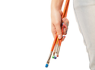 Image showing Hand holding brushes isolated on white