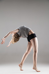 Image showing young beautiful woman in grey T-shirt and black shorts dancing