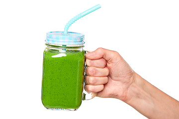 Image showing Human hand holding jar tumbler mug with green smoothie