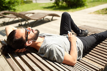 Image showing man with earphones and smartphone listening music