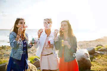 Image showing young women or girls blowing bubbles on beach