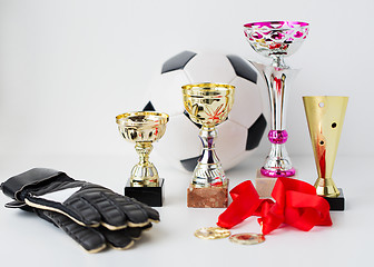 Image showing close up of football, gloves, cups and medals