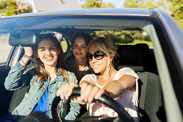 Image showing happy teenage girls or young women driving in car