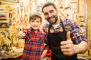 Image showing father and little son making thumbs up at workshop