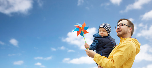 Image showing happy father and son with pinwheel toy outdoors