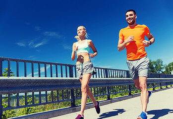 Image showing smiling couple running at summer seaside