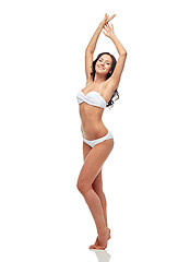 Image showing happy young woman in white bikini swimsuit dancing