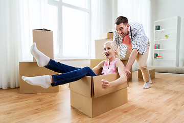 Image showing couple with cardboard boxes having fun at new home