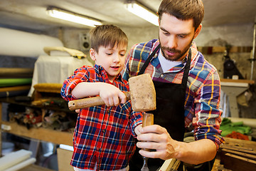 Image showing father and son with chisel working at workshop