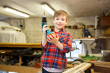 Image showing happy little boy with drill at workshop