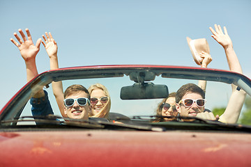 Image showing happy friends driving in cabriolet car at country