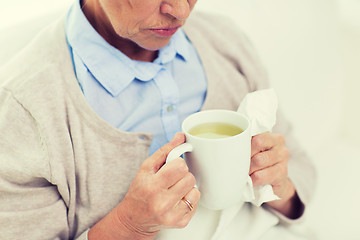 Image showing close up of sick senior woman drinking tea at home