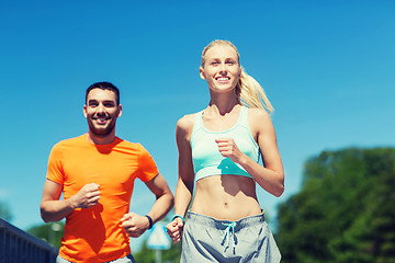 Image showing smiling couple running outdoors