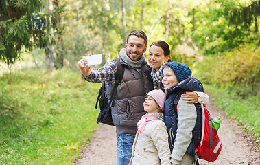 Image showing family with backpacks taking selfie by smartphone
