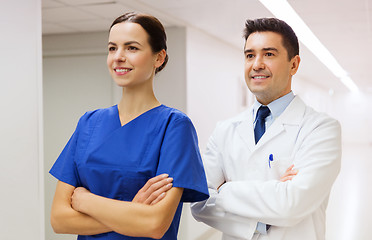 Image showing smiling doctor in white coat and nurse at hospital