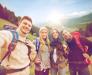 Image showing group of smiling friends with backpacks hiking