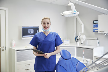 Image showing happy female dentist with tablet pc at clinic