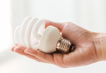 Image showing close up of hand holding energy saving lightbulb