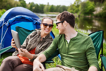 Image showing happy couple with tablet pc at camping tent