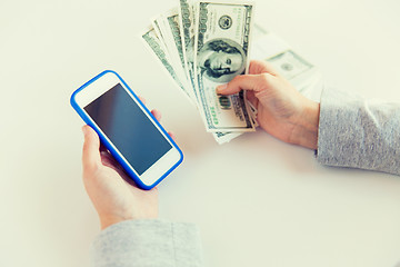 Image showing close up of woman hands with smartphone and money