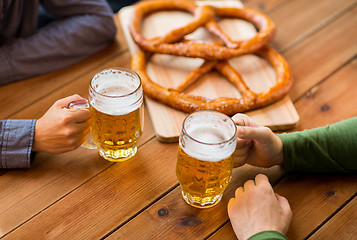 Image showing close up of hands with beer mugs at bar or pub