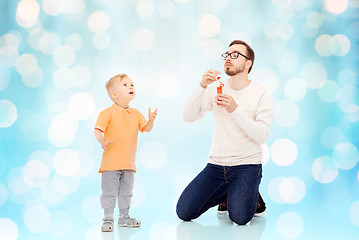 Image showing father with son blowing bubbles and having fun