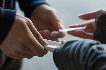 Image showing close up of addict buying dose from drug dealer