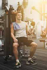 Image showing smiling man exercising on gym machine