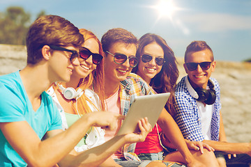 Image showing group of smiling friends with tablet pc outdoors