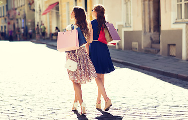 Image showing happy women with shopping bags walking in city 