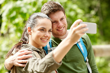 Image showing couple with backpacks taking selfie by smartphone