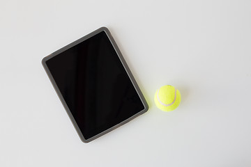 Image showing close up of tennis ball and tablet pc over white