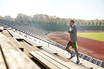 Image showing happy young man running upstairs on stadium