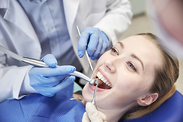 Image showing close up of dentist treating female patient teeth