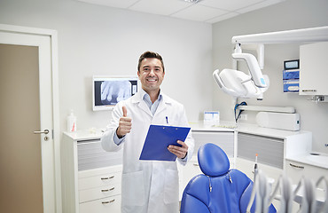 Image showing happy male dentist showing thumbs up at clinic